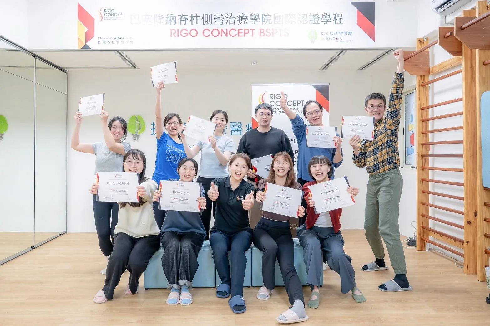 Level 1 課程結業合影：學員手持 Rigo Concept Level 1 結業證書與講師一同歡呼，上方橫幅為「巴塞隆納脊柱側彎治療學院國際認證學程 RIGO CONCEPT BSPTS」